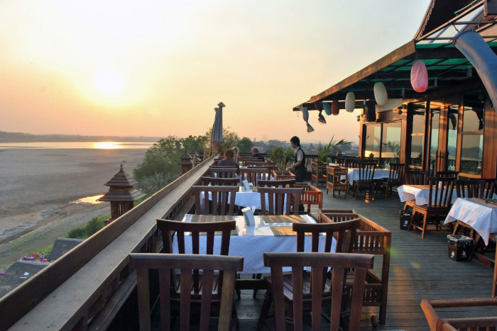 Savor a delightful riverside dinner while soaking in the beauty of Laos, making the most of your Laos itinerary 2 weeks