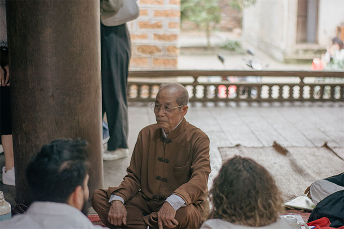 Personel of Mong Phu Communal House telling story to the visitors