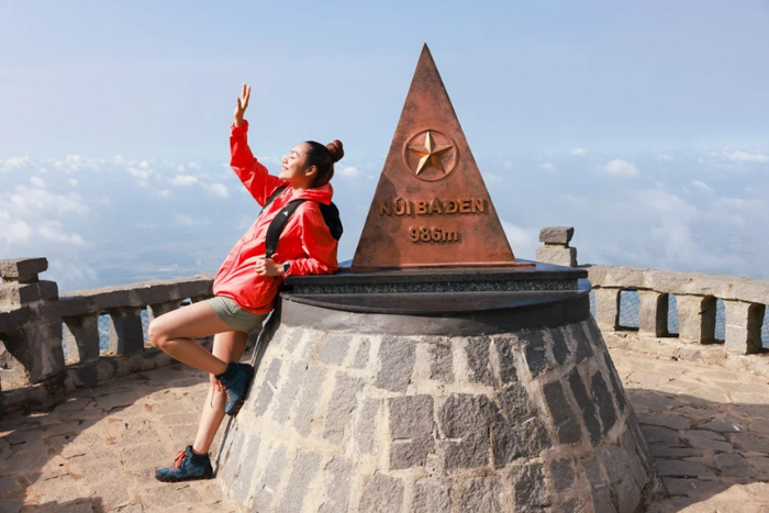 A tourist takes pictures at the peak of Black Virgin Mountain