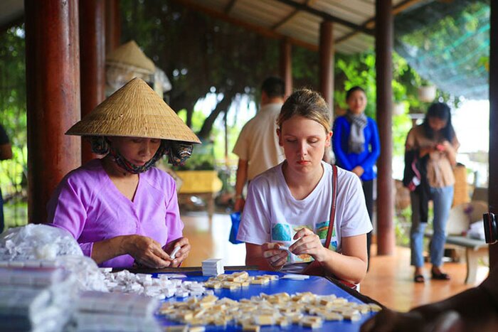 Visitor participates in the experience of a coconut candy making workshop